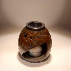 Thème sur le ciel étoilé, en terre de grés, bicolore transparent et bleu/marron. A l'intérieur se trouve une bougie chauffe-plat et au dessus, une grille permettant de déposer quelques grains de résines. Permet de parfumer un lieu, ou de le nettoyer des mauvaises énergies stagnantes.