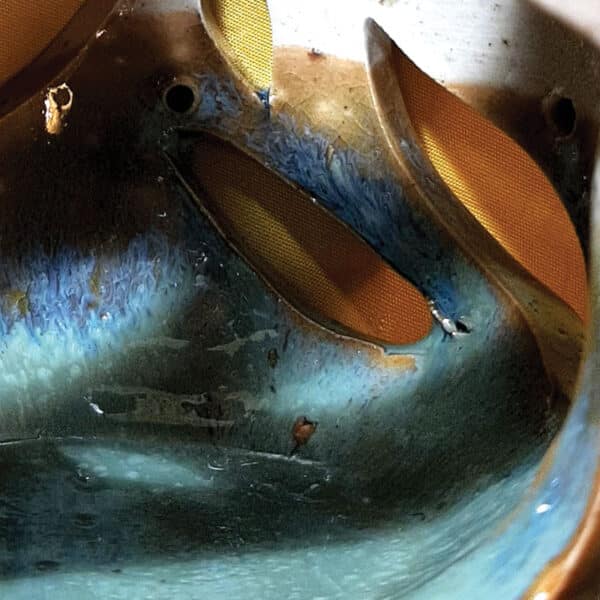 Détail. Brule-résine en terre de grés, émaillé bicolore, transparent et bleu-vert, décor de flamme. A l'intérieur se trouve une bougie chauffe-plat et au dessus, une grille permettant de déposer quelques grains de résines. Permet de parfumer un lieu, ou de le nettoyer des mauvaises énergies stagnantes.