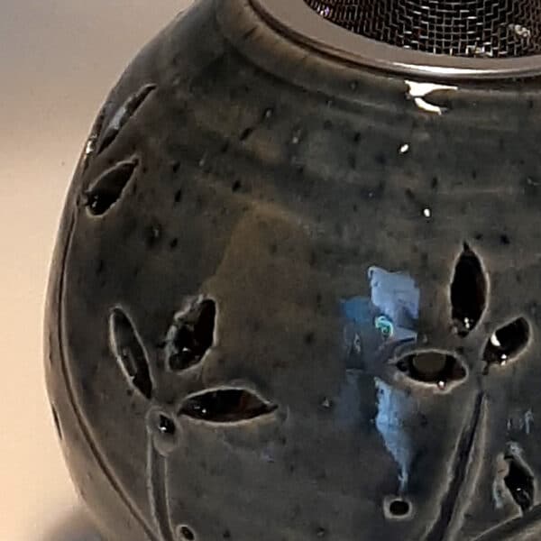 Brûle résine en grès émaillé naturel, ton bleu, forme ronde décorée de fleurs. A l'intérieur se trouve une bougie chauffe-plat et au dessus, une grille permettant de déposer quelques grains de résines. Permet de parfumer un lieu, ou de le nettoyer des mauvaises énergies stagnantes.