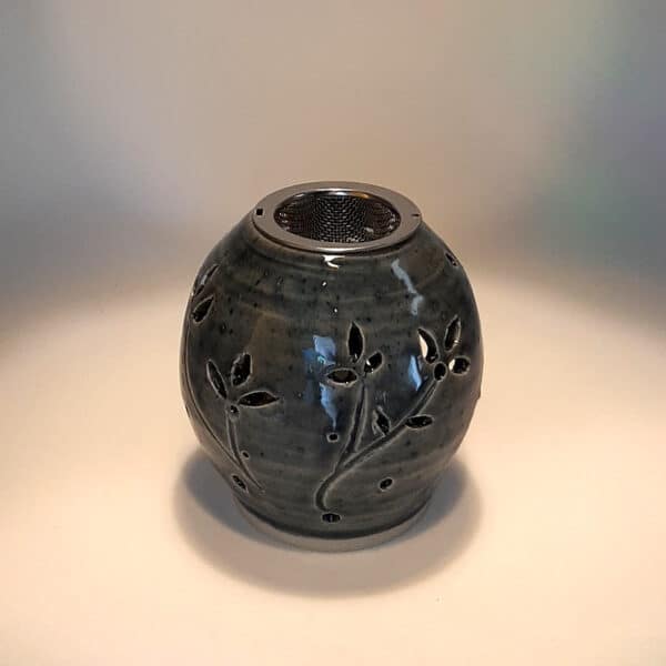 Brûle résine en grès émaillé naturel, ton bleu, forme ronde décorée de fleurs. A l'intérieur se trouve une bougie chauffe-plat et au dessus, une grille permettant de déposer quelques grains de résines. Permet de parfumer un lieu, ou de le nettoyer des mauvaises énergies stagnantes.
