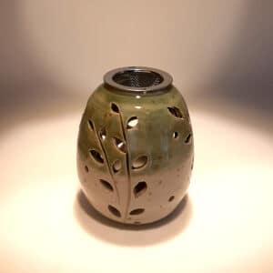 Brule-résine en terre de grés, émaillé bicolore, transparent et vert, décor de fleurs. A l'intérieur se trouve une bougie chauffe-plat et au dessus, une grille permettant de déposer quelques grains de résines. Permet de parfumer un lieu, ou de le nettoyer des mauvaises énergies stagnantes.