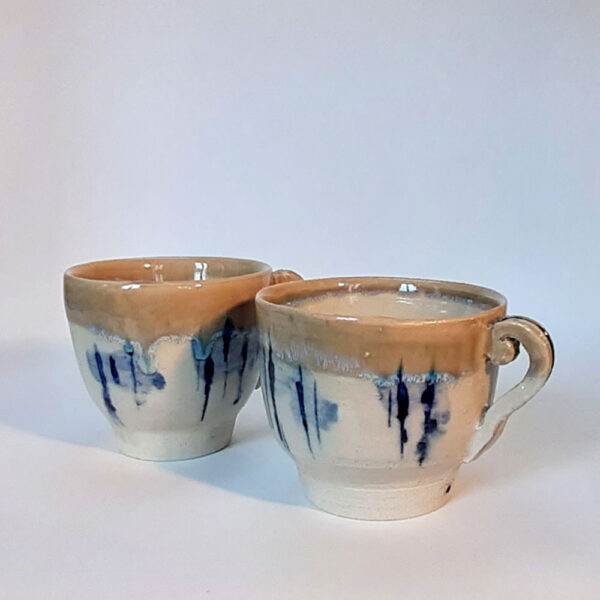 Tasses en duo, en grès blanc, cuisson électrique. Recouverte d'un émail blanc et d'un autre émail sur les bords ce qui créé une réaction chimique et nous fait découvrir un liseré comme le lichen dans des tons bleutés. Motifs design.