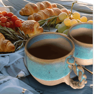 Duo.Petit déjeuner amoureux. En grès clair, émaillé de transparent, cette tasse est bordée d'un liseré couleur terre accompagné d'un bandeau dans les tons bleus céleste. Sa anse vous offre un joli cœur sur une base tressée.