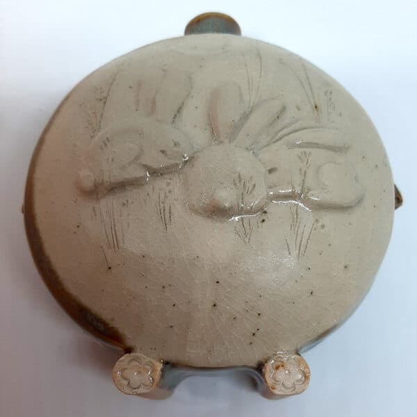 Dans la collection des "Elégantes", vase en grés émaillé Azurite avec motif de lapin sur face avant sur fond transparent. Céramique aux 2 couleurs bleu et marron sur l'arrière, au dos et côté avec effet de matière.
