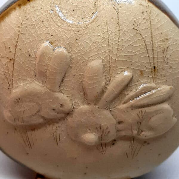 Dans la collection des "Elégantes", vase en grés émaillé Azurite avec motif de lapin sur face avant sur fond transparent. Céramique aux 2 couleurs bleu et marron sur l'arrière, au dos et côté avec effet de matière.
