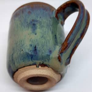 Détail. Mug avec anse en grés émaillé Azurite. De 2 couleurs bleu et marron avec effet de matière. Parfait pour les soirées d'hiver devant la cheminée ou dans son canapé. Vue de dessous.