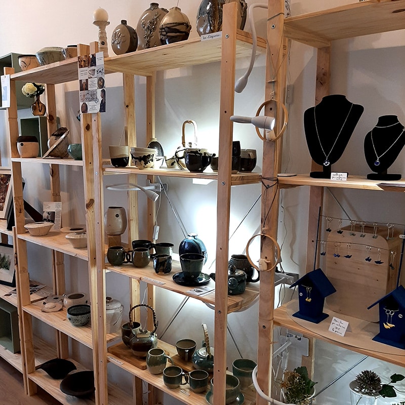 Intérieur de la boutique Arti Bleu à Lectoure, 63 rue Nationale. Présentation de nos céramique sur une étagère en bois.