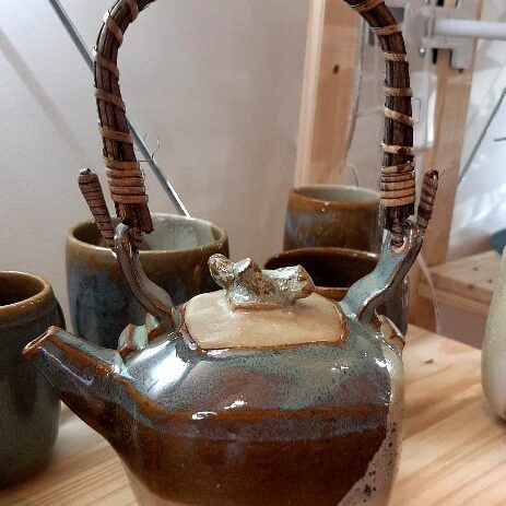 Théière en grés émaillé avec anse en osier. De 2 couleurs bleu et marron avec effet de matière. Collection Azurite.